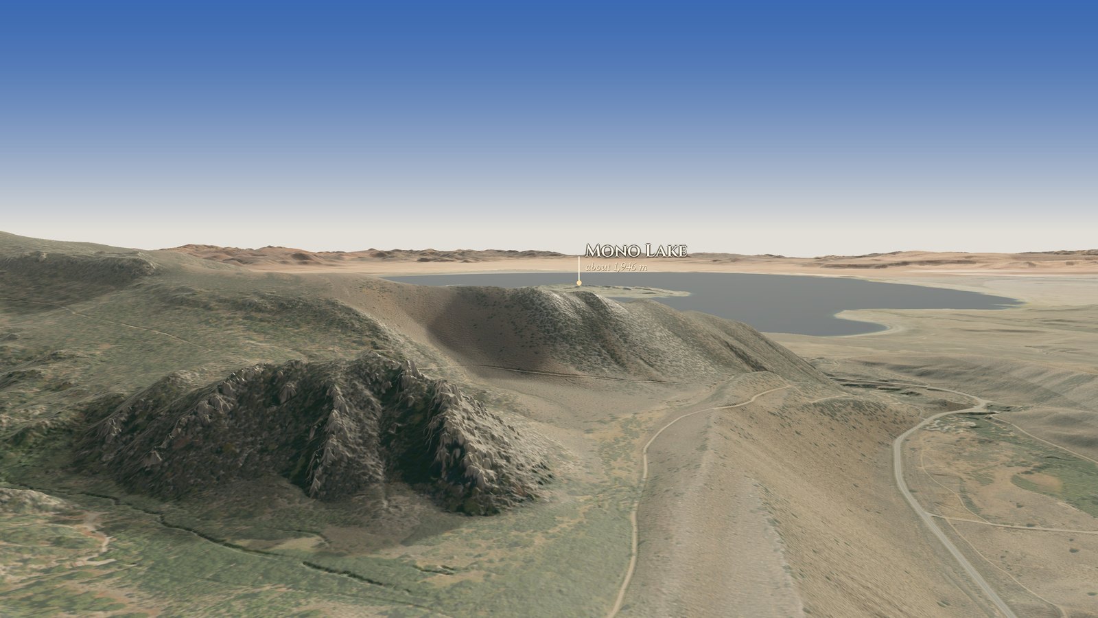 Coming out of the mouth of Lee Vining Canyon over a rocky ridge and an old road, with Mono Lake spreading out beyond