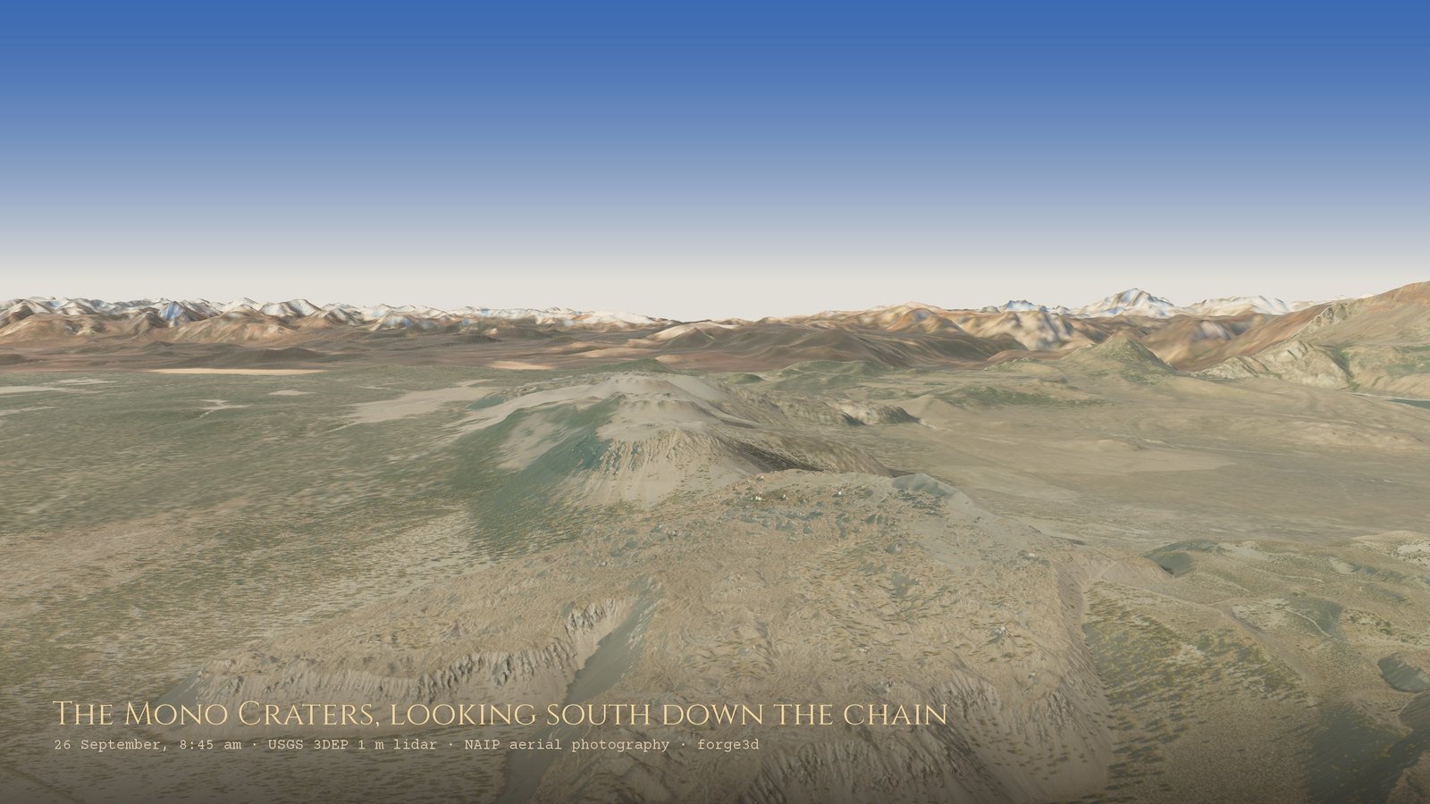 Looking south down the Mono Craters chain from the air: a line of pale, flat-topped lava domes with steep, blocky flanks running into the distance, with the snow-dusted Sierra Nevada on the horizon