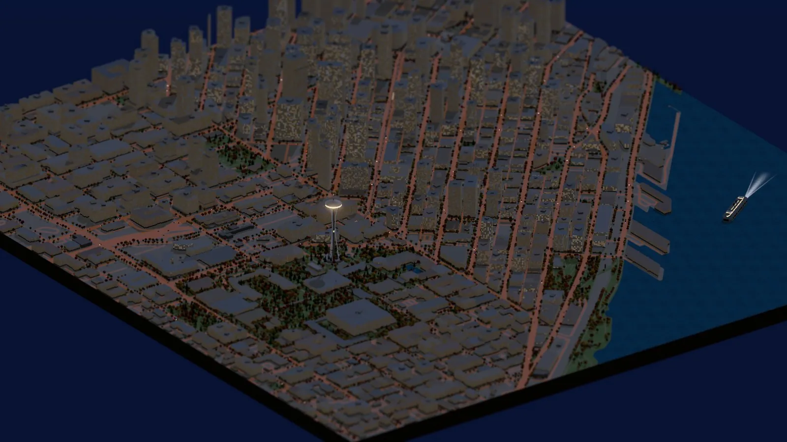 The miniature city at night: thousands of lit windows, orange streetlight glow along the street grid, the Space Needle's top glowing, and Elliott Bay shimmering