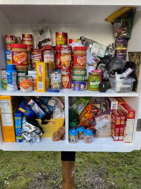 Close-up of pantry shelves packed with canned goods, soups, rice, and hygiene items